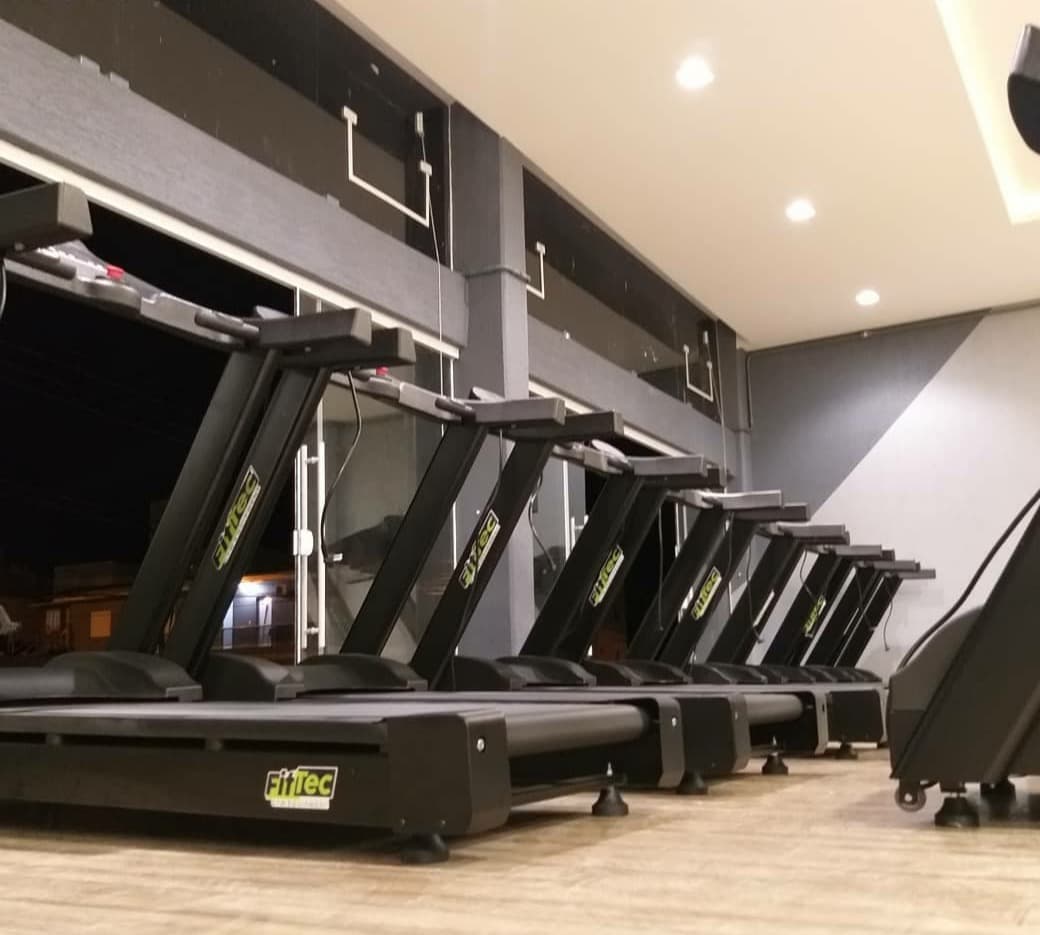 Sala de academia totalmente equipada com esteiras, bikes e estações de musculação da FitTec Gym